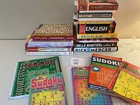 Top-down view of the full lot showing stacks of books including cookbooks, Sudoku puzzle books, biographies, and self-help books in varied colors and sizes.