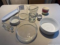View of all 14 glass and ceramic bowls and serving dishes on a textured surface, showcasing variety of sizes and materials.