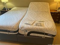 Full view of two mattress halves on split king foundation with bedside tables visible