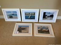 Set of 5 white framed photographic prints arranged on floor, showing all items and frames in landscape orientation.