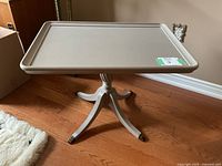 Full view of the light grey painted wood accent table showing the raised edge top and pedestal base.