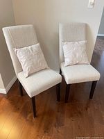 Front view of both upholstered chairs with pillows