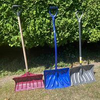All three snow shovels standing upright
