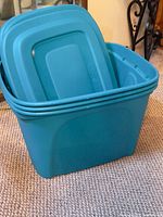 Teal storage tote with multiple lids stacked inside