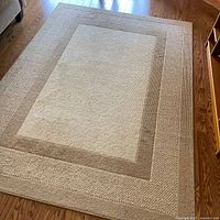 Full view of rug on hardwood floor showing overall design and size