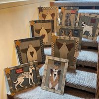 Group shot of all nine framed plaques displayed on stairs