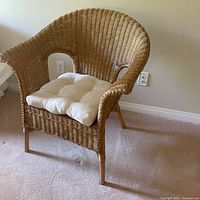 Front view of wicker armchair with cushion