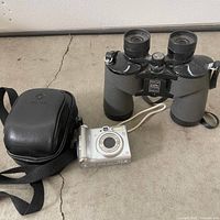 Group shot of binoculars, camera and case