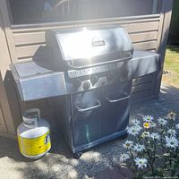 Front view of Broil-Mate stainless propane grill with propane tank attached