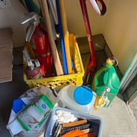 Overview of crate holding fire extinguisher, broom handles, fluid containers, wipes, dustpan and brush