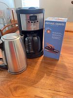 Coffee maker, kettle, boxed mandoline on table