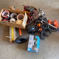 Overview of lot showing camera box, tapes, fixtures, plunger, measuring tools, hand tools