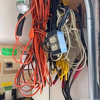 Overall view of extension cords and jumper cables hanging