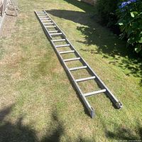 Full view of wooden extension ladder on lawn