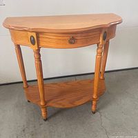 Front view of wood half-moon console table