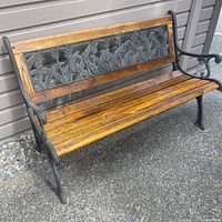 Overall view of bench showing wood slats and iron back panel