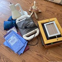 Group shot showing neck massager, lamp, frames, pillow, straw figurine, sealed fabric packs