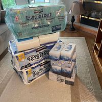 All items stacked: paper towel pack, bath tissue pack, Kleenex boxes