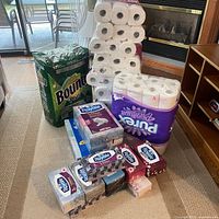 Overall lot with Bounty pack, stacked loose toilet paper, Purex pack, multiple facial tissue boxes