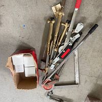 Lot overview showing torch valves, pulley, hand tools, and box