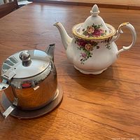 Royal Albert teapot, stainless teapot and coaster on tabletop