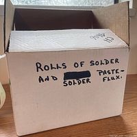 Closed cardboard box marked "Rolls of Solder and Solder Paste Flux"