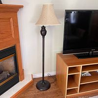 Full view of floor lamp beside fireplace and TV