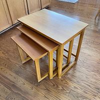 Three teak nesting tables stacked together showing design and finish