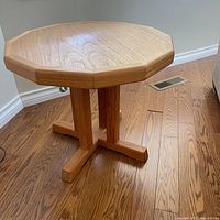 Full view of teak side table showing top, pedestal and base