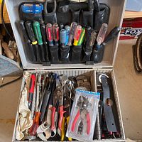 Overall view of open metal case with tools in lid and base