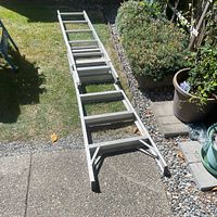Full view of aluminum tripod ladder on lawn