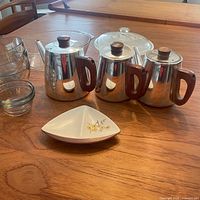 Group shot showing both Sona pots, glass casserole with lid, five glass bowls and triangular English dish