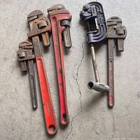 Group shot of all wrenches and vice on concrete floor