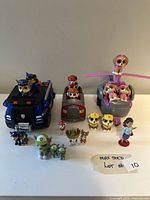 Wide shot showing all Paw Patrol characters and vehicles included in the lot on a white table with handwritten lot number 10