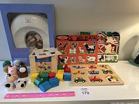 Photo showing Baby Bjorn toilet training seat boxed unused, Melissa & Doug sound puzzle, Montessori style shape sorter cube with colorful pieces, wooden farm puzzle pieces and animals