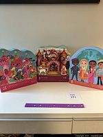 Three assembled Crocodile Creek floor puzzles displayed on a shelf: Mermaid Palace, Princess Castle, and Children Characters themes.