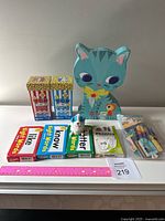 Photo showing letter and word popcorn game packages, a large kitty puzzle, multiple sight words and phonics card packs arranged with a ruler for size reference