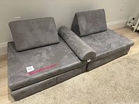 Two seat cushion modules side by side with two backrests and central bolster arranged on floor