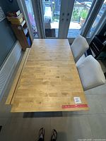 Top view of wooden extendable kitchen breakfast table with ruler for scale.