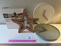 Square wooden wall shelves set in original box next to hanging star and clocks