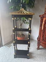 Full front view of shelf showing pagoda top, three shelves, gold detailing