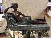 Front view of reclining female sculpture on chaise