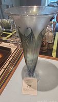 Full view of the trumpet-shaped vase showing the gold pulled feather design with green and blue accents.