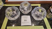 Set of three Kosta Boda Snowball textured glass votive holders displayed on a dark surface with auction lot number visible.