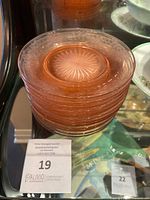 Stack of 12 pink glass luncheon plates showing the starburst center, scalloped edges with star etching, and translucent flamingo pink color.