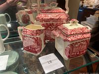 Front angle of the Mason's Ironstone pink vista teapot set, showing all three pieces on glass shelf.