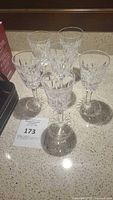 Six Waterford Lismore cut crystal sherry wine glasses arranged on a countertop showing front and top views.