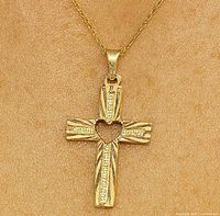 Front view of the 10K gold cross pendant showing the heart-shaped cutout and texture.