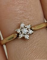 Close-up photo showing the diamond cluster on yellow gold band, highlighting the star-shaped arrangement of diamonds.