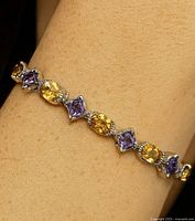 Full bracelet laid flat showing alternating citrine and amethyst stones.